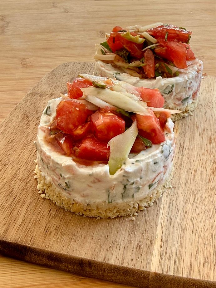 Une base de biscuit, du fromage frais et de la tomate